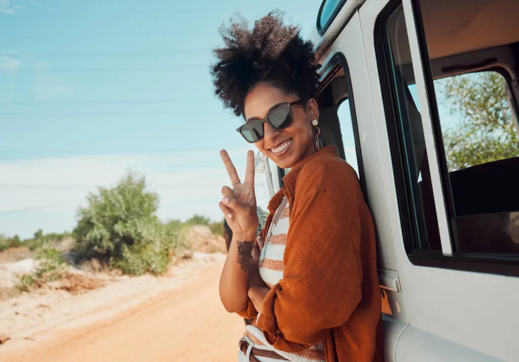Travel, van and black woman with peace hand sign on road trip in Mexico